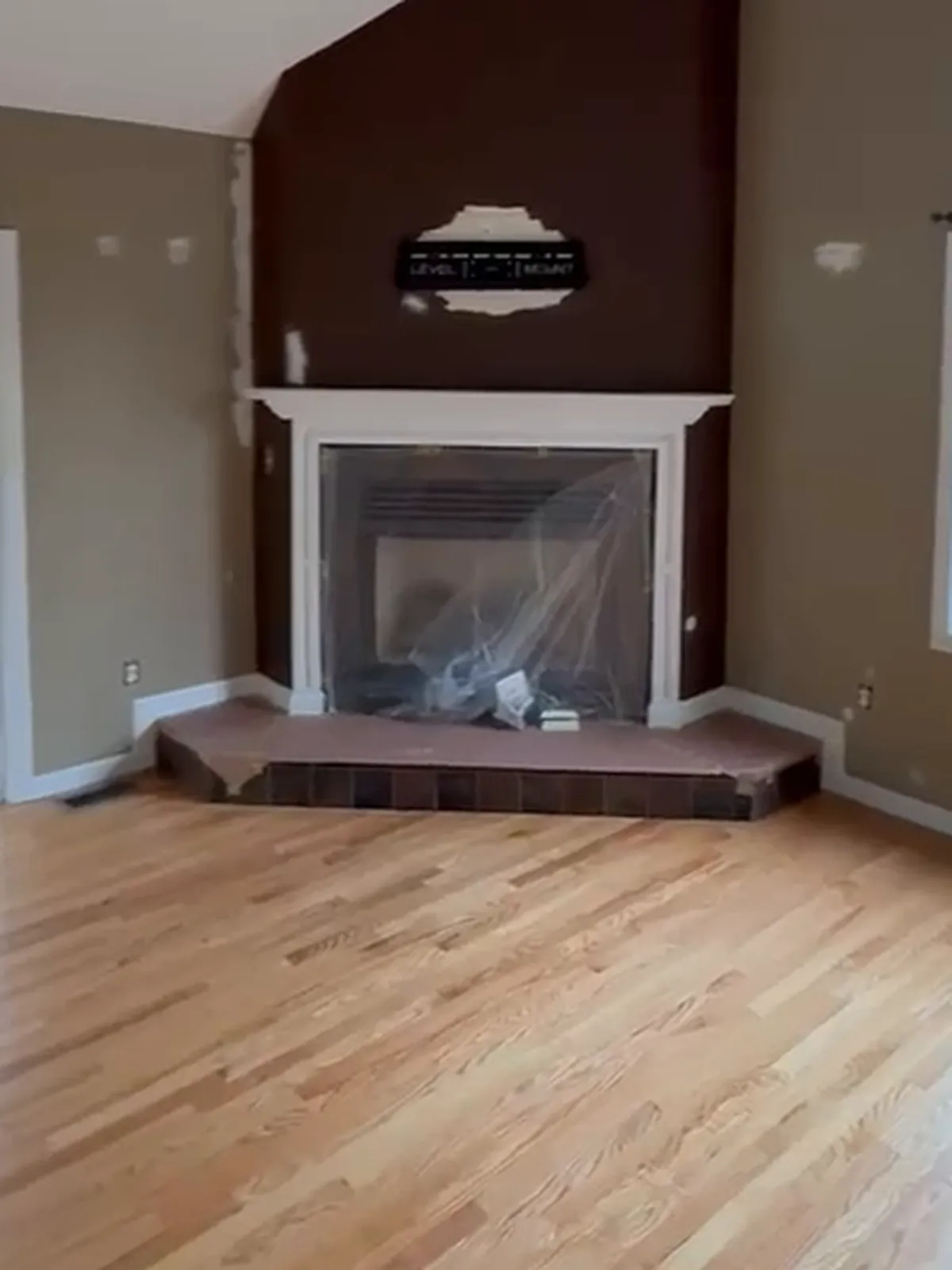 Interior Painting in Douglas, MA, before: Fireplace wall: the dark brown accent repainted sage green. Before frame taken from the crew's walkthrough video.